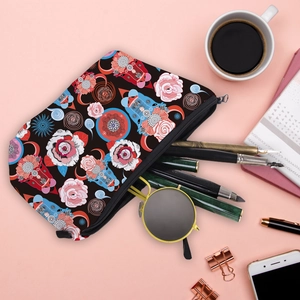 Waterproof travel cosmetic bag with vibrant floral print and zipper closure on pink desk