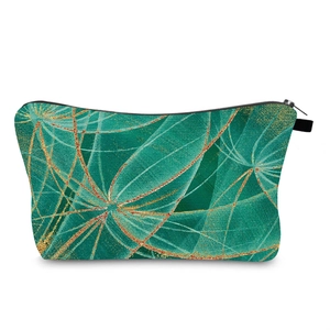 Detail of green toiletry bag featuring gold dandelion print and sturdy metal zipper