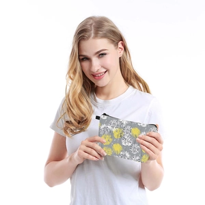 Waterproof dandelion print cosmetic bag held by a model for travel storage