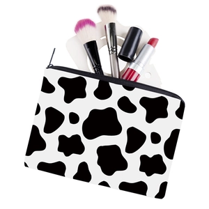 Portable cow print square makeup bag with black and white spots and zipper closure