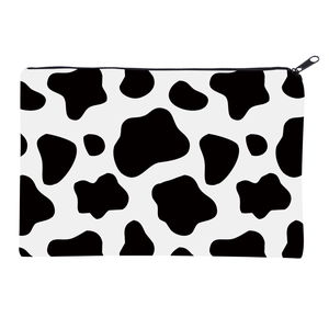 Flat view of a rectangular cow print makeup bag featuring a black zipper on a white canvas