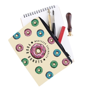 Detailed close-up of donut print travel makeup bag with stationery items on desk