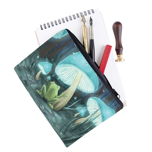 Detail of mushroom and frog print pouch with office stationery on white background