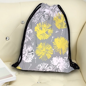 Grey drawstring backpack with yellow dandelion digital print on a white leather sofa