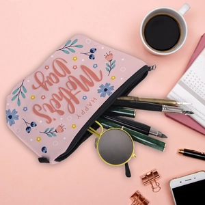Pink Mother's Day cosmetic bag with floral print, flat lay on desk with daily accessories