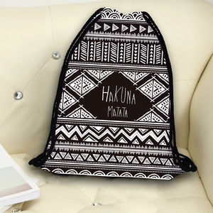 Ethnic geometric drawstring backpack with Hakuna Matata print on a beige sofa