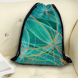 Green drawstring backpack with abstract dandelion print on a white leather sofa background
