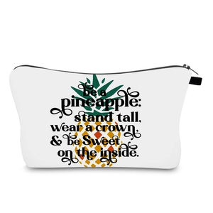 Detail of pineapple print and motivational quote on a white waterproof cosmetic bag