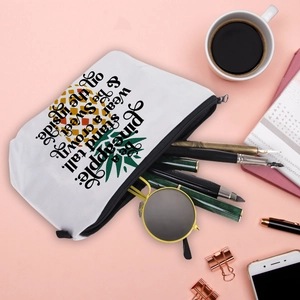 Waterproof pineapple print cosmetic bag with quote on a stylish pink tabletop setup