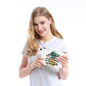 Waterproof pineapple print cosmetic bag held by a smiling woman in a casual white t-shirt