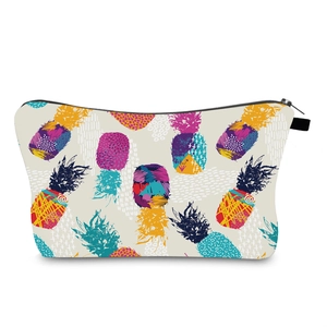 Close-up of shell-shaped makeup bag featuring colorful pop art pineapple prints and black zipper
