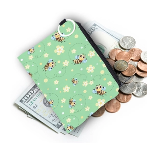 Compact green coin purse with bee print shown with dollar bills and coins on white background