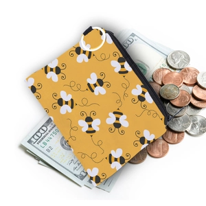 Waterproof bee print coin purse with metal ring shown on dollar bills and coins