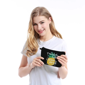 Waterproof pineapple print makeup bag being held by a female model on white background