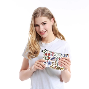 Floral print portable cosmetic bag with colorful flowers held by a female model
