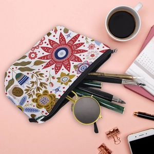Vue à plat de la trousse à fleurs avec lunettes et stylos sur un bureau rose