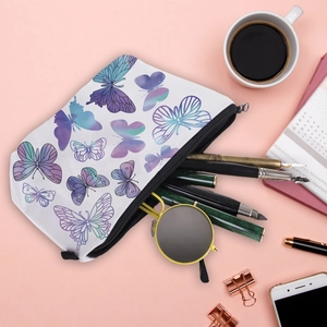 Détail d'une trousse à maquillage papillon avec fournitures de bureau sur fond rose