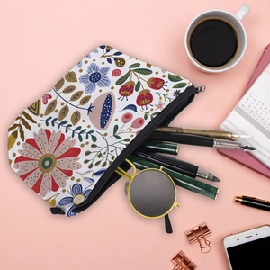 Flat lay of floral pattern travel makeup bag with coffee cup and office accessories
