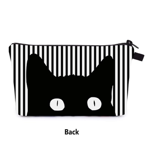 Detail view of the back of a black cat printed striped cosmetic bag with a zipper