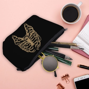 Black cosmetic bag with gold skull butterfly print holding sunglasses and stationery