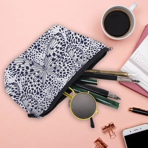 Detail of butterfly print makeup bag with sunglasses and pens for travel storage