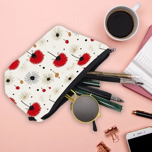 Portable travel makeup bag with dandelion print, pens and sunglasses on pink background