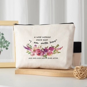 Linen makeup bag with purple floral print and quote on a wooden surface for travel