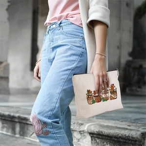 Linen style cosmetic bag with Christmas gingerbread prints held against a stone background