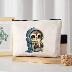 Linen makeup bag with cute owl graphic in a warm wooden tray lifestyle scene