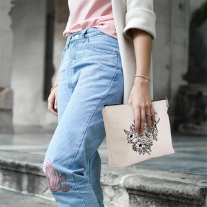 Linen style cosmetic bag with owl pattern held by model in street photography macro shot