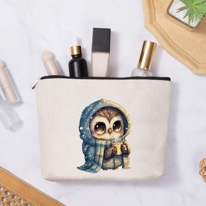 Linen makeup bag with cartoon owl pattern and toiletries on marble tabletop