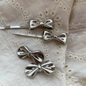 French style metallic silver bow hair clip set on elegant floral embroidery background