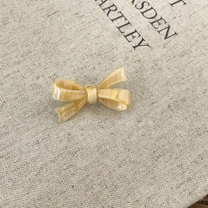 Detalle macro de un pasador de pelo de acetato crema con grabado hecho a mano