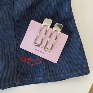 Barrettes à cheveux minimalistes en métal argenté avec texture martelée sur denim bleu