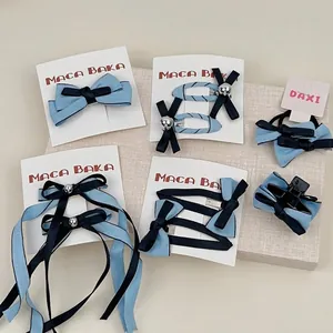 Lot de barrettes à nœuds bleu clair et marine sur un présentoir beige