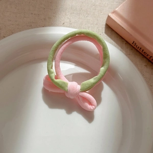 Pink and green layered scrunchie with a cute butterfly bow on a white ceramic display