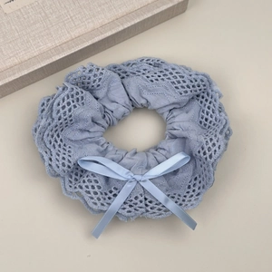 Detail view of light blue lace scrunchie with delicate bow and wavy embroidery edges