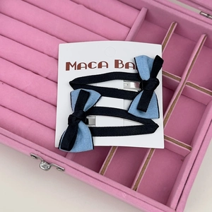 Détail des barrettes à cheveux à nœud en ruban bleu et noir sur carte de support