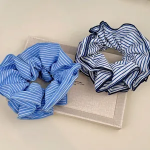 Chic blue and white striped fabric scrunchies displayed on a beige display tray