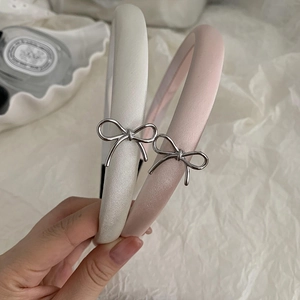 Elegant satin padded headband with silver metal bow detail in cream white and soft pink