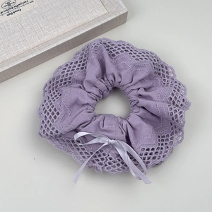 Detailed view of lavender lace scrunchie with cotton fabric and delicate silk bow