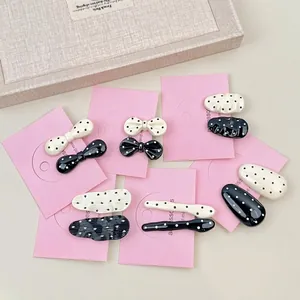 French style black and white polka dot hair clip set on a beige textured tray