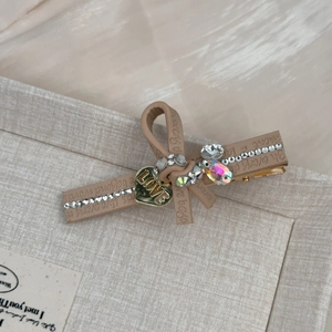 Détail de la barrette à cheveux en cuir marron clair avec cœur LOVE et strass brillants