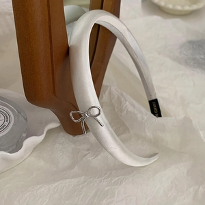Elegant white satin headband featuring a delicate silver metal bow charm for women