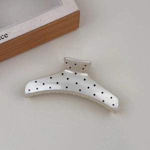 Detail of large French polka dot hair claw clip with glossy pearlescent white finish