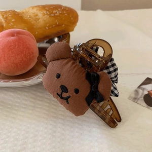 Detail der flauschigen braunen Bärenhaarklammer mit bernsteinfarbener Basis und Schleife