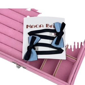 Lot de barrettes à nœuds bleu et noir sur carte dans une boîte en velours rose