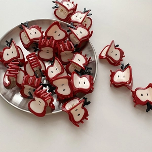 Pinces à cheveux en forme de pomme rouge et blanche en acétate avec détail de feuille