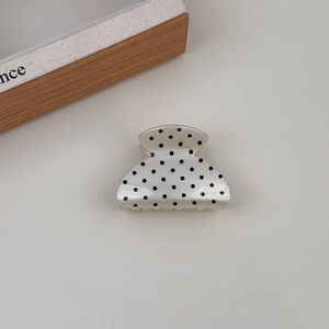Detailed close-up of a French style polka dot hair claw clip with smooth polished finish