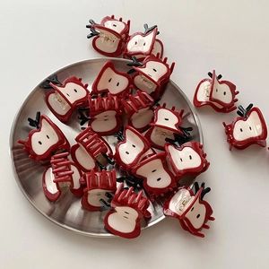 Pinces à cheveux mignonnes en forme de pomme rouge en acétate sur un plateau en argent